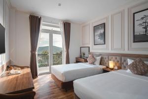 Postel nebo postele na pokoji v ubytování Dalat Roof Hotel