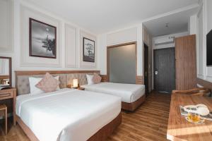Postel nebo postele na pokoji v ubytování Dalat Roof Hotel