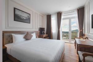 Postel nebo postele na pokoji v ubytování Dalat Roof Hotel