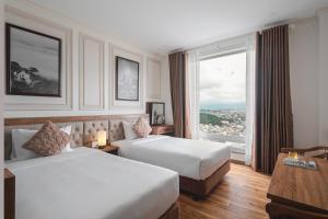 Postel nebo postele na pokoji v ubytování Dalat Roof Hotel