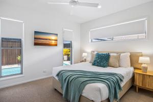 a bedroom with a bed and a window at Premium 4-Bed Coastal Escape with BBQ and Pool in Peregian Beach +10 photos