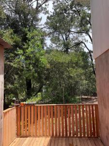 une terrasse en bois avec des arbres en arrière-plan dans l'établissement Cabaña lo de Antonia, à Estación Costa Azul