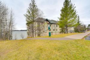 a house on a grassy hill with a sidewalk at Pool and Lake Access Northern Lakes Retreat! in Two Harbors