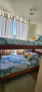 two bunk beds in a room with a window at Cond Bahia Pelicano in Puchuncaví