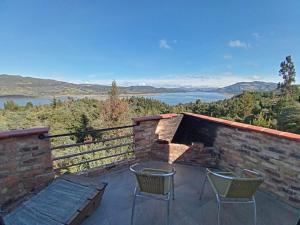 a patio with two chairs and a table and a view at Casa Boutique Abadia de Tomine in Guatavita