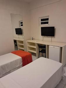 レシフェにあるPousada Recife Tropicalのベッドが2つと机とコンピューターがある部屋