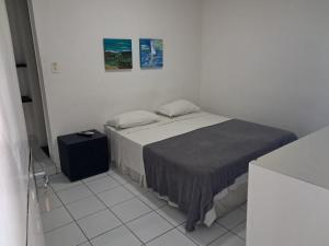 a white room with a bed and a table at Pousada Recife Tropical in Recife