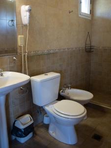 a bathroom with a toilet and a sink at Complejo de cabañas- Lomas del Sol in Los Reartes +26 photos