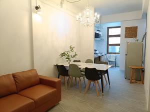 ein Wohnzimmer mit einer Couch und einem Tisch und Stühlen in der Unterkunft Grey Brown Green house at chiangmai old town in Chiang Mai