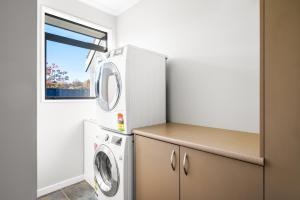 a laundry room with a washer and dryer at Beacon Point Retreat by Sotheby's Luxury Rental Homes in Wanaka