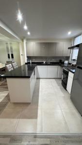 a large kitchen with white cabinets and a black counter top at PentHouse Categoria Centro in Villa María +3 photos