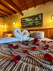 a bed with two swans and roses on it at Pousada Valle Paradiso in Praia do Rosa +76 photos