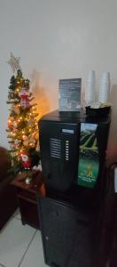 a television and a christmas tree in a room at Pousada DL in Pelotas +1 photo