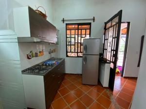 a kitchen with a stove and a refrigerator at Cabaña Campestre - Puente Nacional in Puente Nacional +11 photos
