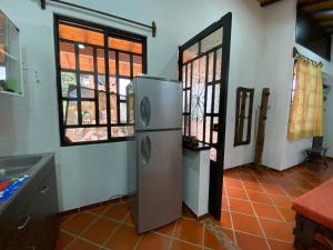 a kitchen with a refrigerator in a room with windows at Cabaña Campestre - Puente Nacional in Puente Nacional