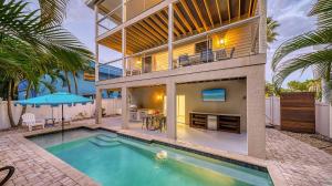 a house with a swimming pool in front of a house at Island Escape - 638 in Siesta Key