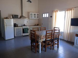 a kitchen with a table and chairs and a refrigerator at Los Gurises in Balneario El Condor