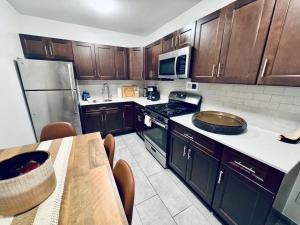 cocina con armarios de madera, mesa y fogones en Charming Hoboken, a few Minutes to Manhattan, en Hoboken