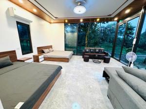 ハノイにあるPalm Villa - Venuestayの部屋にベッドとソファがある寝室