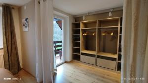 a walk in closet with glass doors and a window at La Renardière in Labaroche