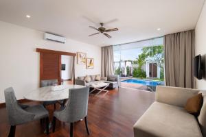 スミニャックにあるThe Daha Luxury Villasのリビングルーム(テーブル、椅子付)