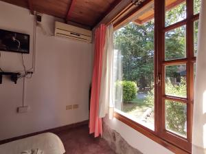 a living room with a window and a television at Cabañas La Toscana in Tandil