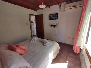 a bedroom with a white bed with pillows on it at Cabañas La Toscana in Tandil +38 photos