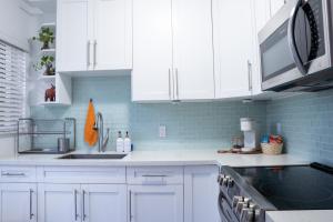 a kitchen with white cabinets and a sink at Casa MIA central location, free parking, fully equipped in Miami