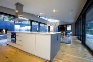 a kitchen with white cabinets and a stove top oven at Aspen Grove by Sotheby's Luxury Rental Homes in Queenstown +13 photos