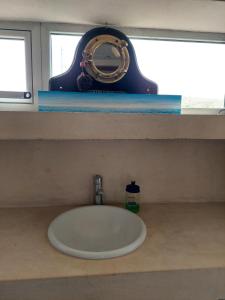 a sink in a bathroom with a mirror on a shelf at Casa camarones in Camarones