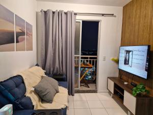 a living room with a blue couch and a television at Apto Araçagy Ilha de São Luis in São-José-do-Ribamar