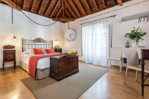 a bedroom with a bed and a table and a clock at Gar Anat Hotel Boutique in Granada