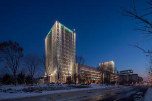 a tall building with green lights on top of it at Holiday Inn Liaoyuan City Center by IHG in Liaoyuan