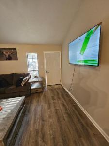 un soggiorno con TV a schermo piatto a parete di The Cozy Townhome a Tallahassee