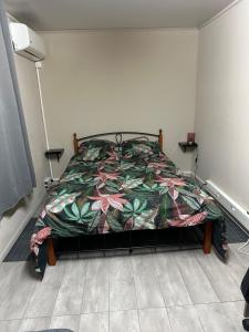 a bedroom with a bed with a colorful comforter at Le petit bungalow in Sainte-Anne