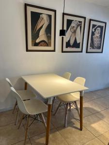 サン・ミゲル・デ・トゥクマンにあるOro Centro Suitesの壁に絵が描かれた部屋のテーブルと椅子 +6枚の写真