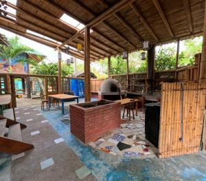 an outdoor patio with a brick oven and tables at La Perla Hostel and Cabins in Las Tunas