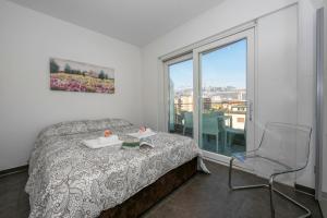 a bedroom with a bed and a chair and a window at Via al Chioso in Lugano