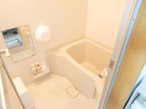 a small bathroom with a tub and a toilet at section-inn in Chitose