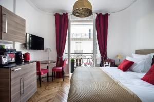 a bedroom with a bed and a kitchen with a table at Beauquartier - Champs-Elysées in Paris