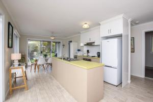 a kitchen with white cabinets and a yellow counter top at River Retreat in American River