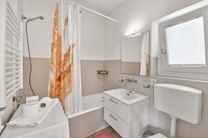 Un baño blanco con inodoro y lavabo. en Casa di Tino - Happy Rentals, en Losone