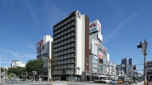 un edificio alto en la esquina de una calle de la ciudad en AB Hotel Sakaihigashi, en Sakai
