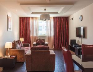 a living room with a couch and a chair at Dunes Hotel Apartment Oud Metha, Bur Dubai in Dubai