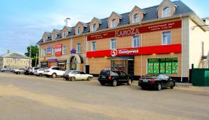 un gran edificio con coches estacionados frente a él en KaroZa, en Petrovskoye