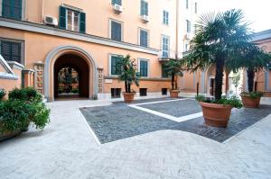 a courtyard with palm trees in front of a building at Flaminio Butterfly House in Rome