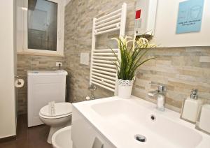 La salle de bains est pourvue de toilettes et d'un lavabo avec une plante. dans l'établissement Flaminio Butterfly House, à Rome 20 autres photos