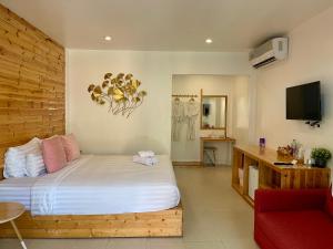 格兰岛บ้านเห็ด เกาะล้าน的带一张床和一张红色沙发的卧室