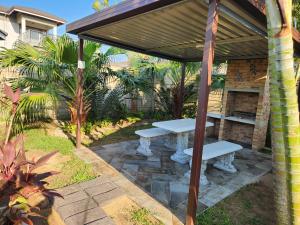 - une table de pique-nique sous un pavillon dans un jardin dans l'établissement Weaver's Corner Richards Bay, à Richards Bay