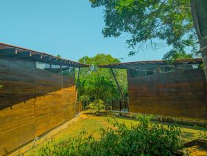 un edificio con una pared de madera junto a un árbol en Southern Edge Cabanas, en Tangalle 16 fotos más